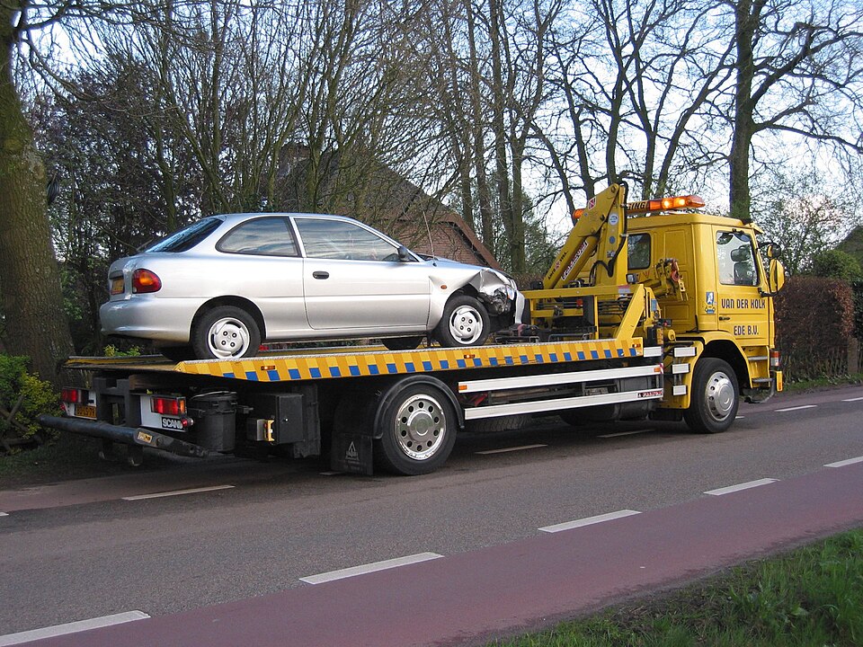 Nevažiuojantis automobilis vežamas tralu